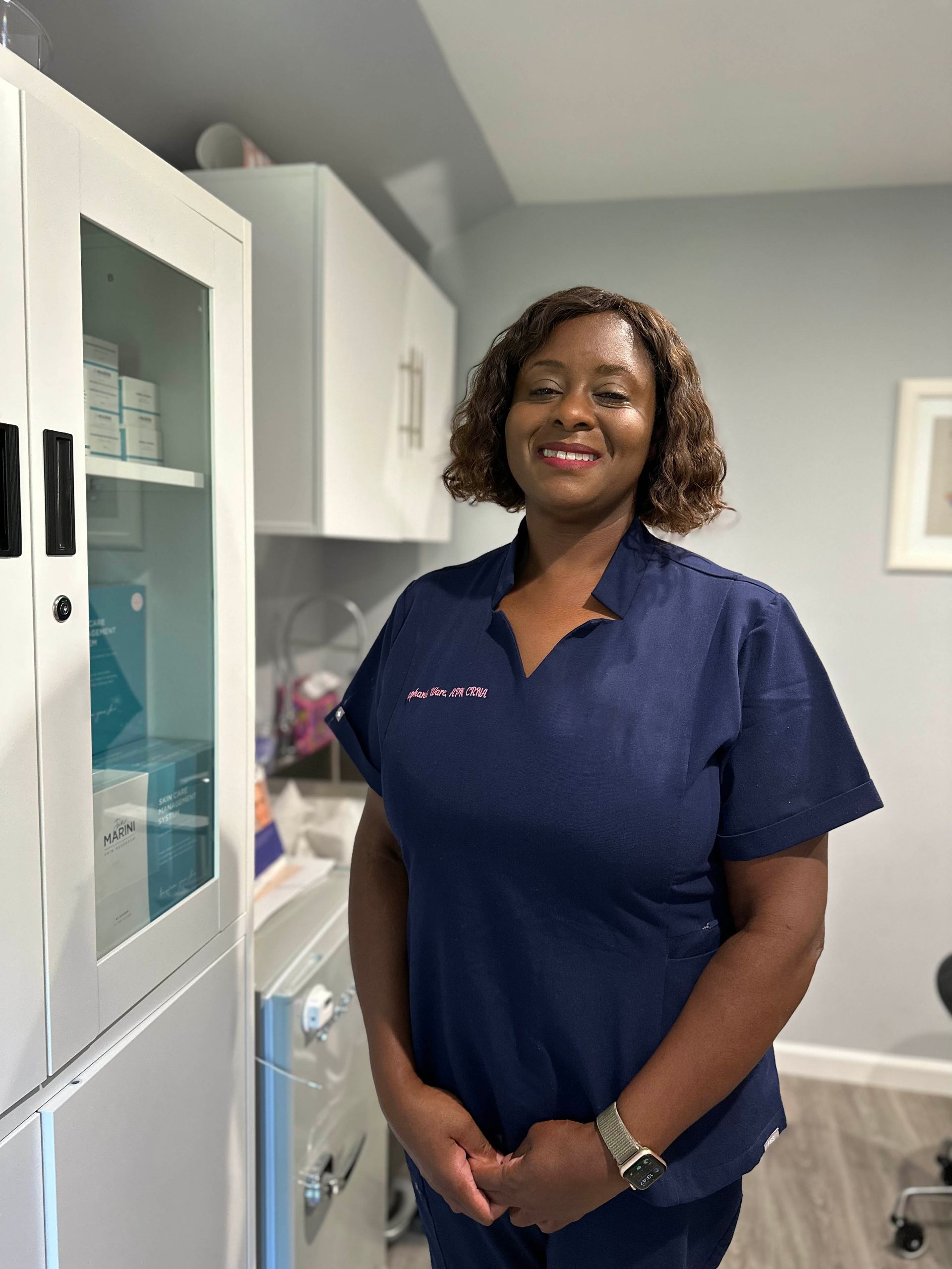 Stephanie Ware poses with clasped hand inside her clinic